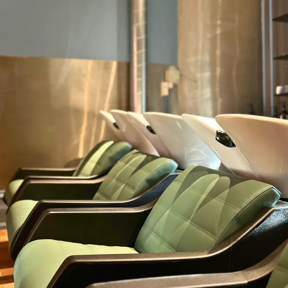 Inside Blue Tit Copenhagen's wash area, wooden floors and comfortable chairs